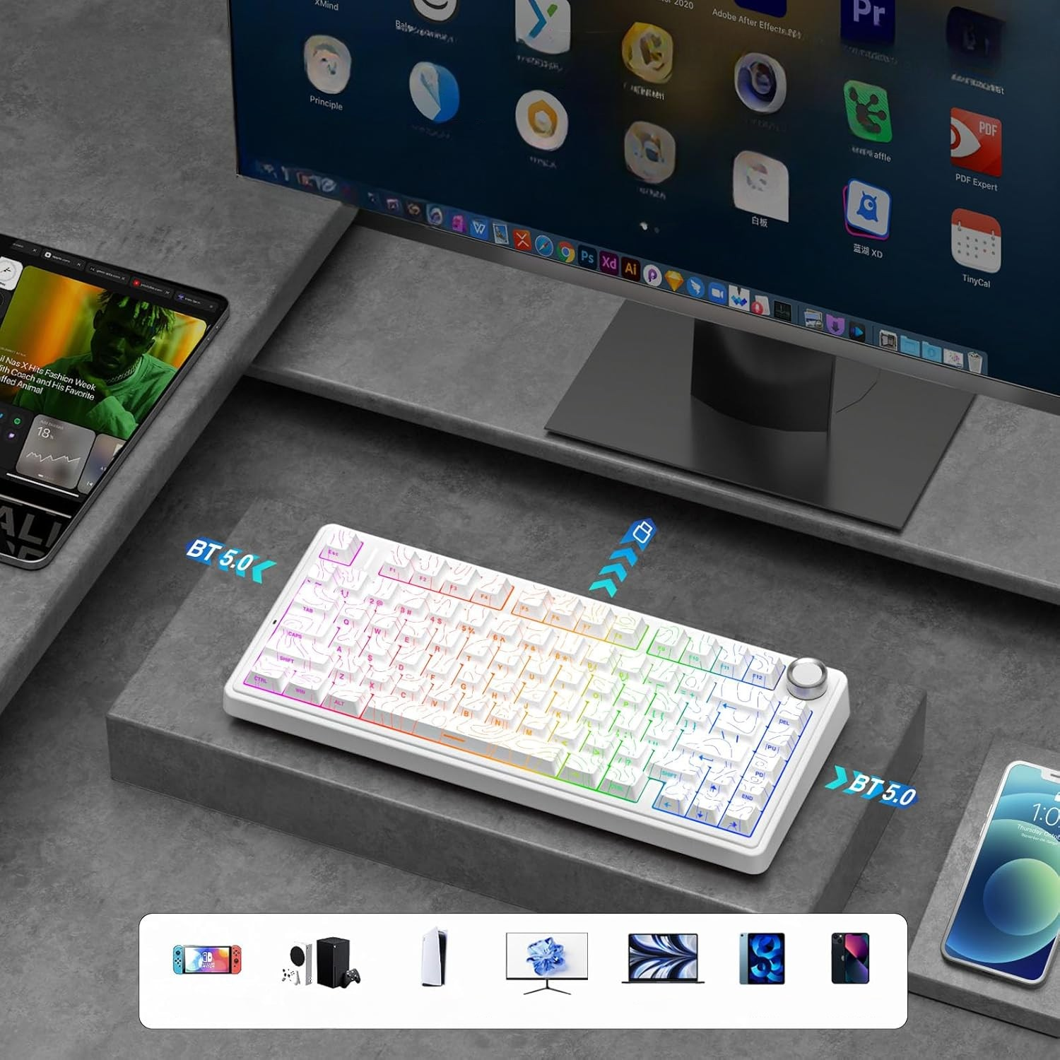 Biała klawiatura RGB, tablet, monitor i smartfon na betonowej powierzchni.