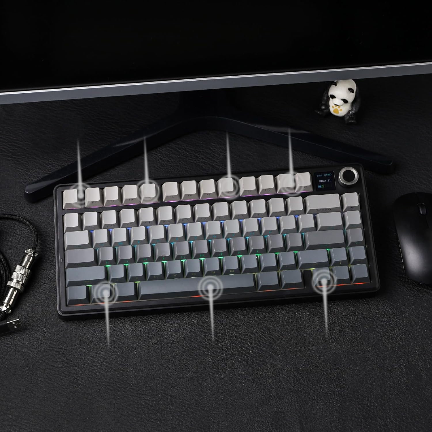 Szara klawiatura mechaniczna z podświetleniem RGB leży na czarnej powierzchni obok myszy.