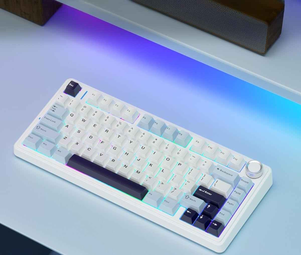 Biała klawiatura z podświetleniem RGB na niebieskim biurku.