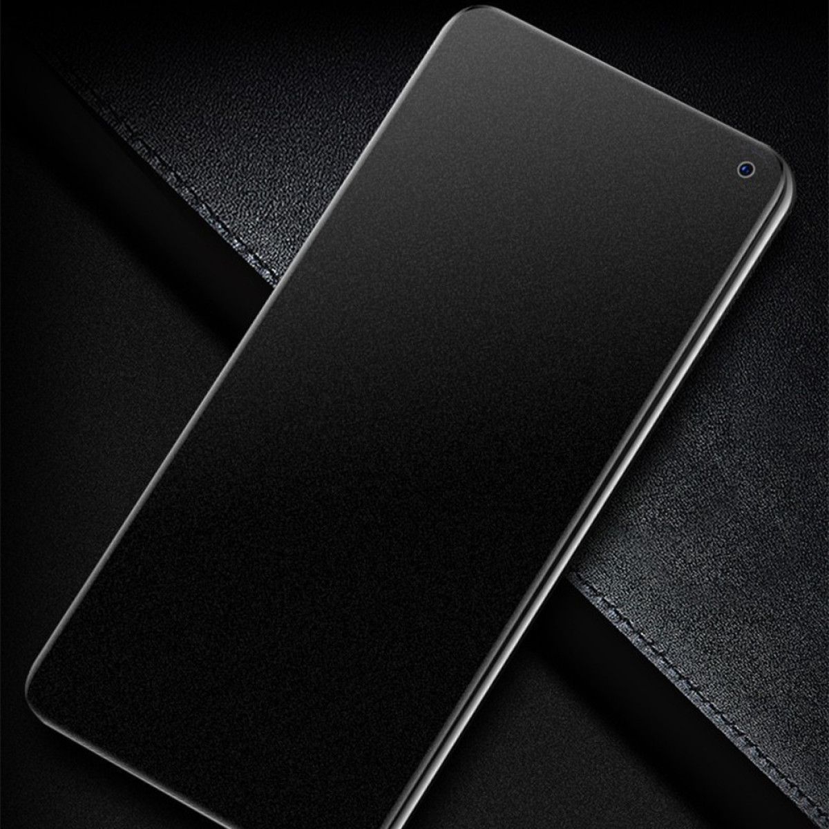 Smartphone nero con un piccolo foro circolare per la fotocamera in alto a destra, su pelle scura.