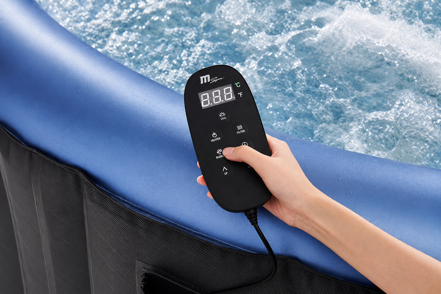 Una mano sostiene un control remoto de jacuzzi sobre agua burbujeante.