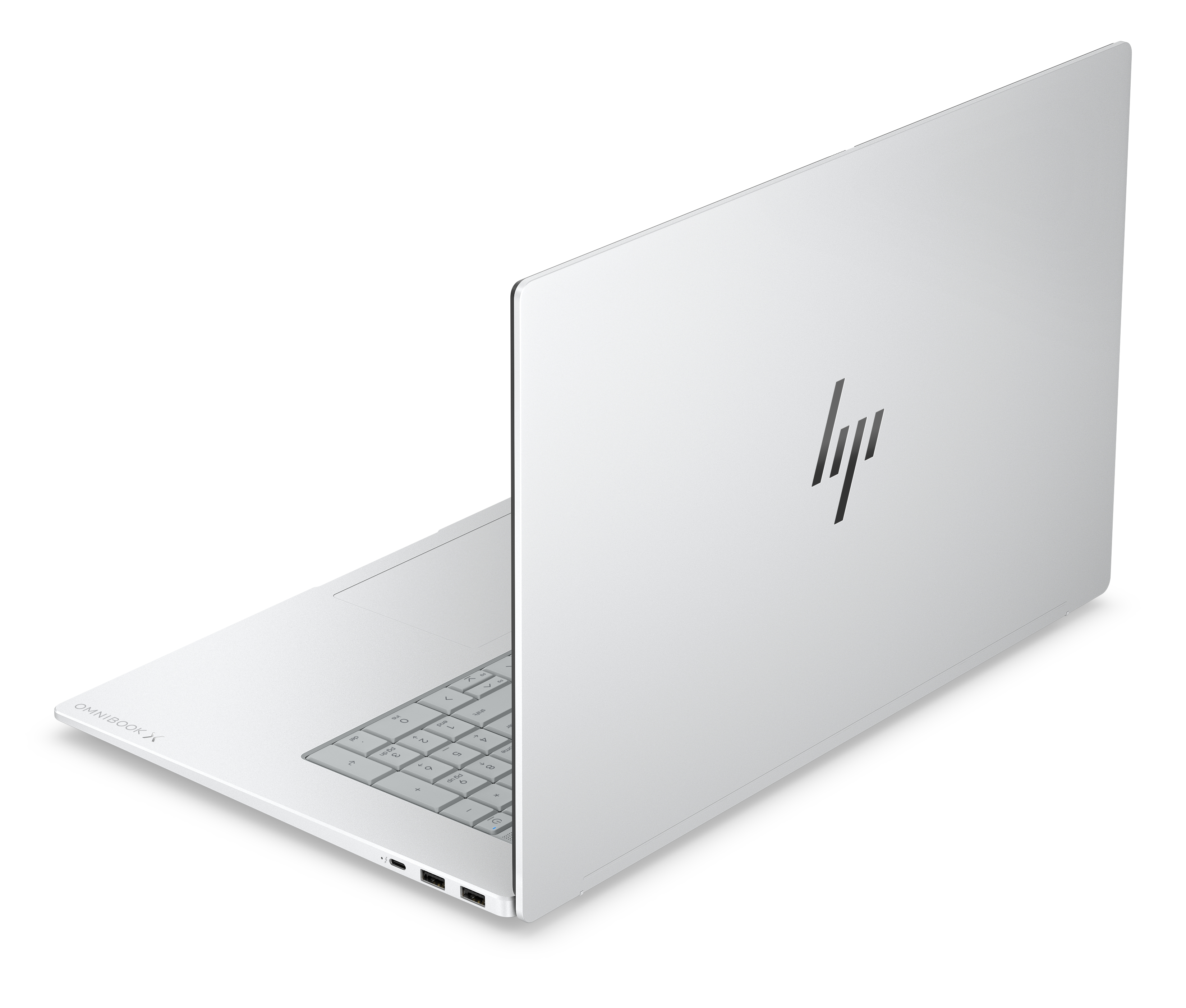Un laptop HP Omnibook X color argento, visto dall'alto, è aperto su uno sfondo bianco, rivelando la tastiera.