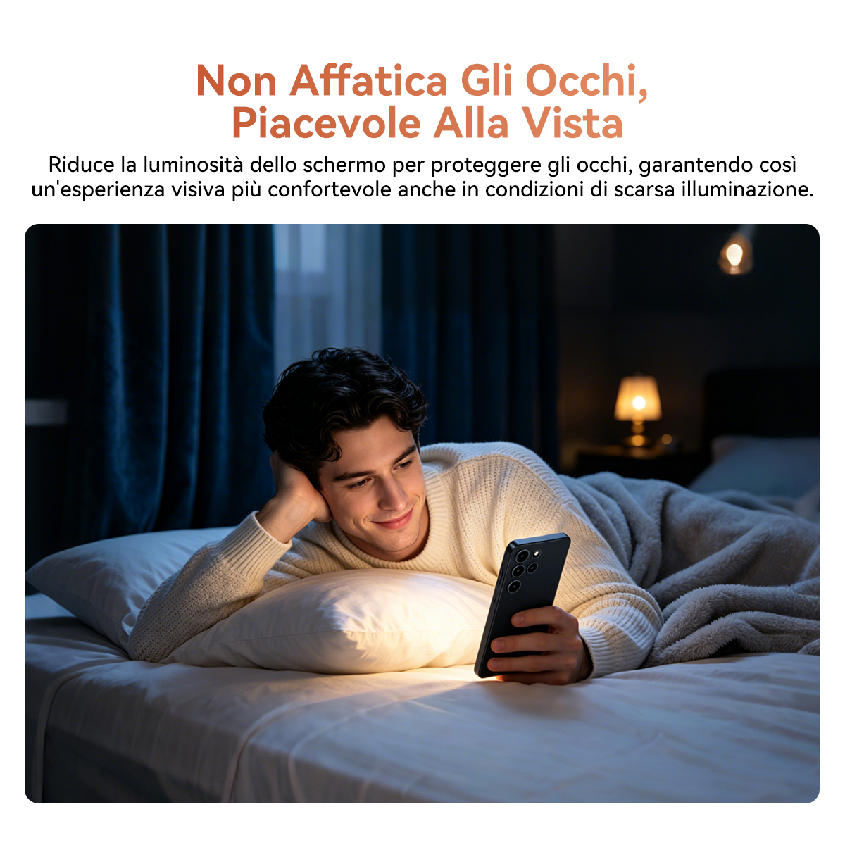 Un uomo è sdraiato a letto, sorride al suo telefono in una stanza buia, con una luce soffusa che gli illumina il viso.