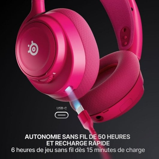 Primo piano di una cuffia wireless rosa con un cavo USB-C blu luminoso collegato, su sfondo scuro.
