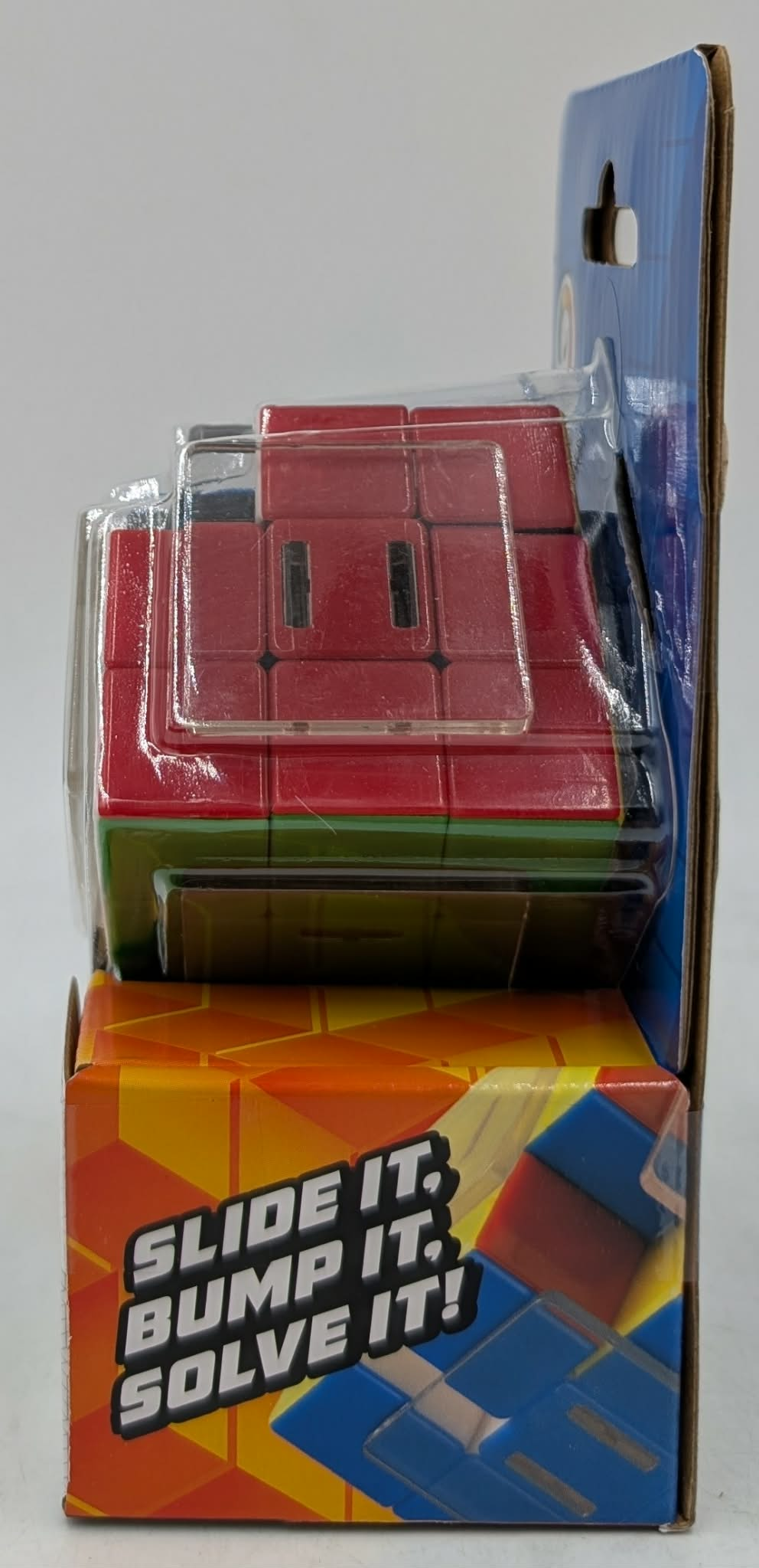 Ein rot-grünes Blockpuzzle in klarer Verpackung, mit Text 