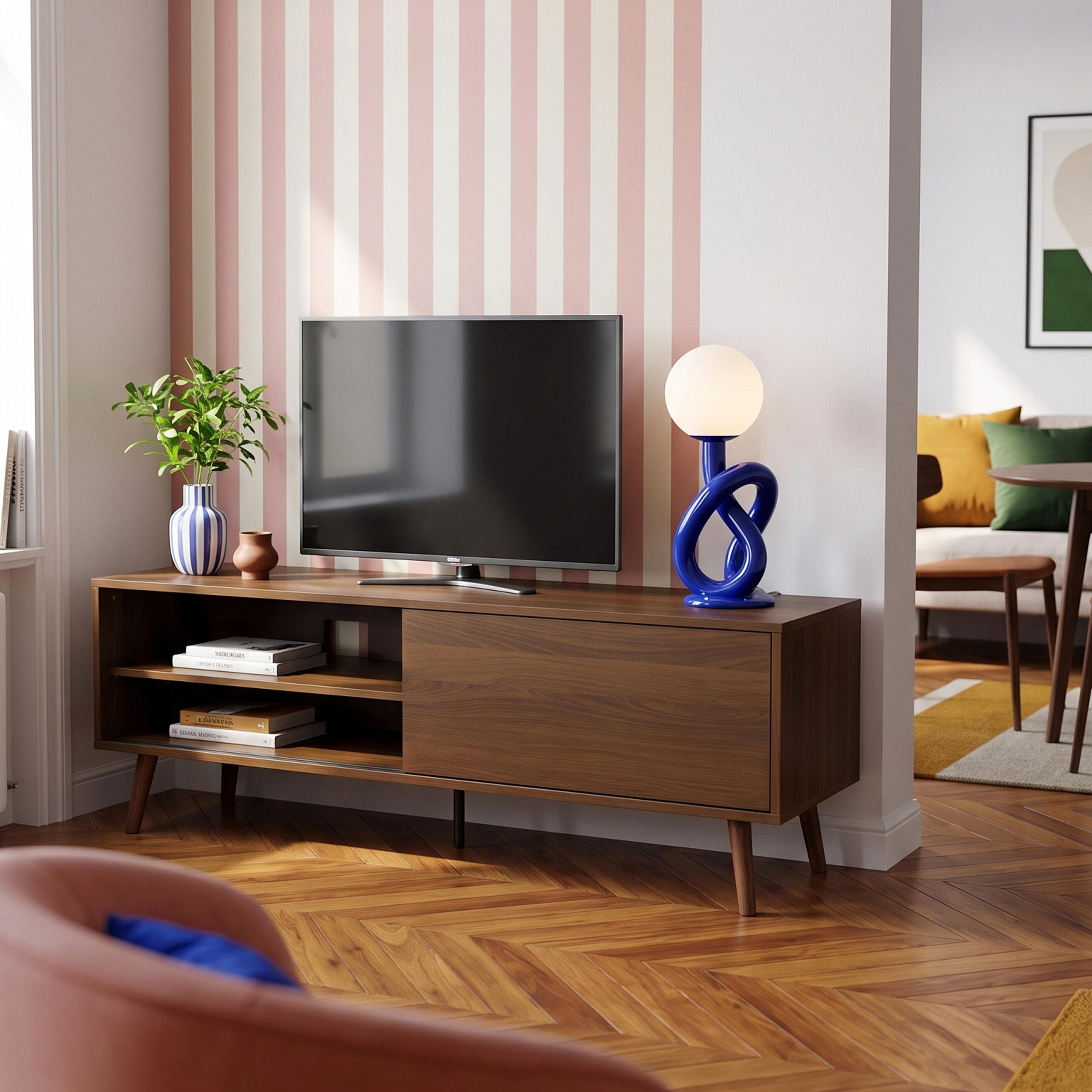 Ein Holzfernsehschrank mit einem Fernseher, einer Lampe und Pflanzen.