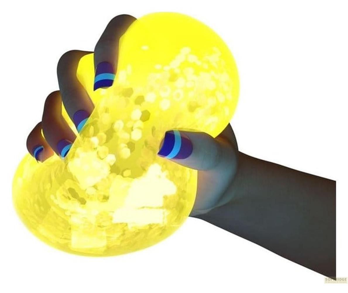 Eine Hand mit blau-lila Nägeln quetscht einen leuchtend gelben, glitzernden Ball.
