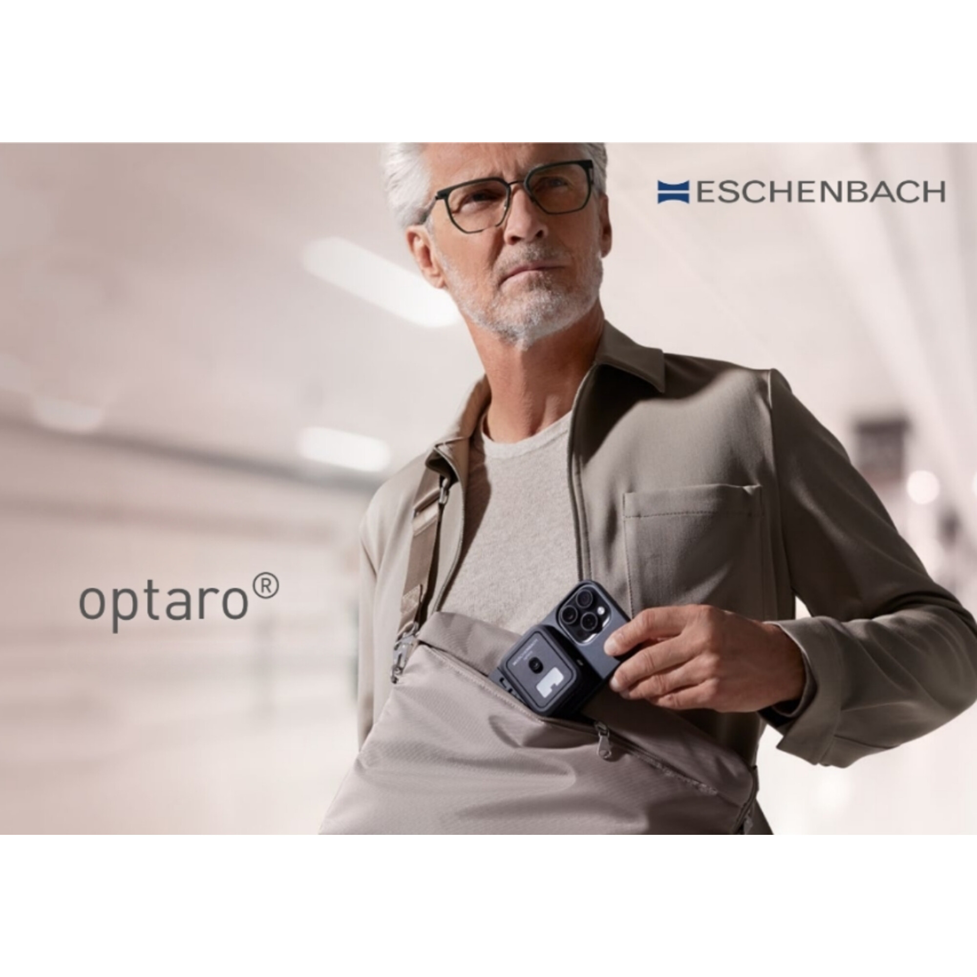 Ein Mann mit Brille holt ein Smartphone aus einer Tasche.