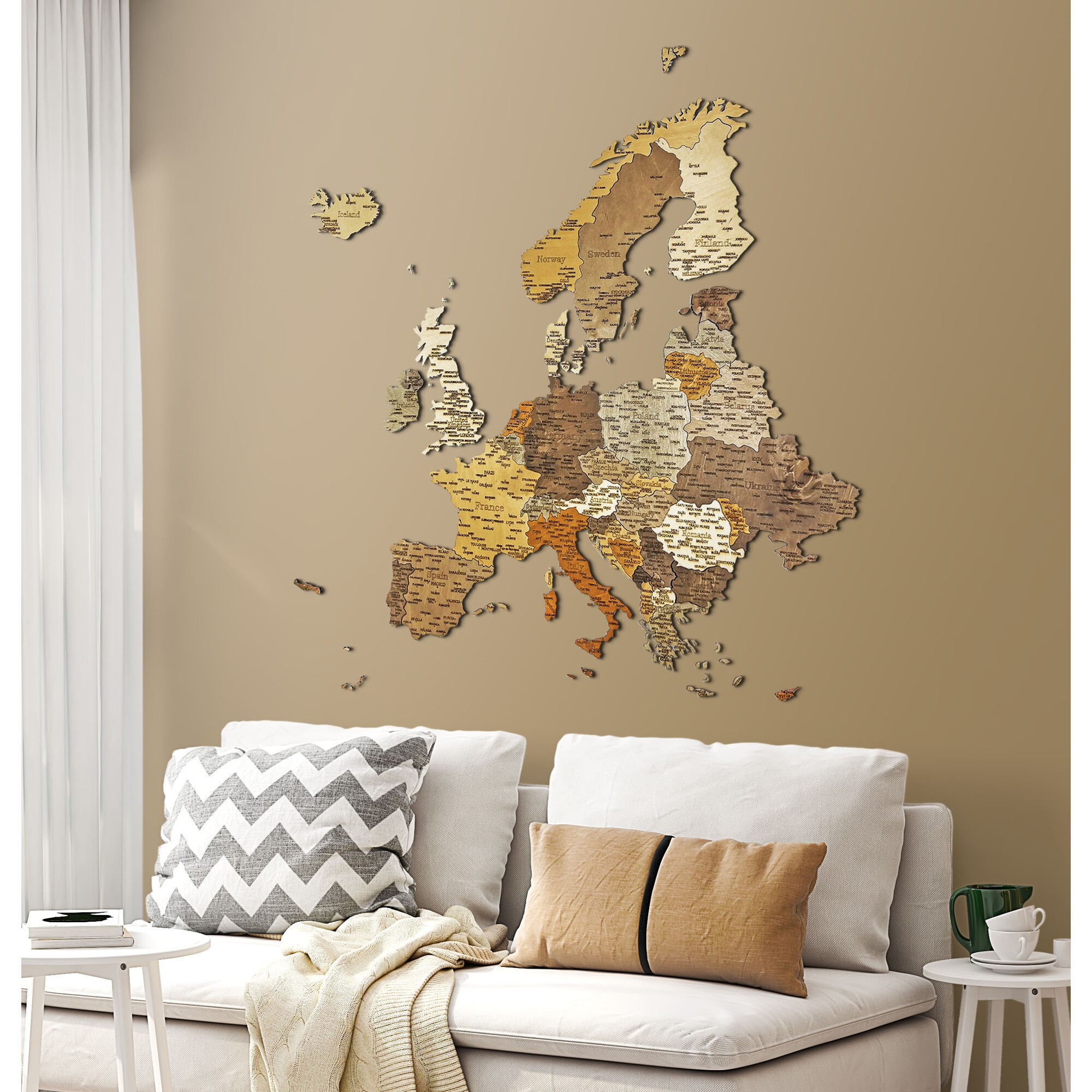 Holzkarte von Europa an einer Wand über einem Sofa mit Kissen und Decke.