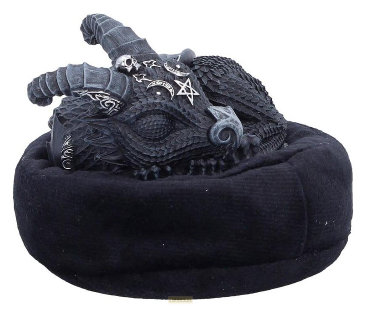 Eine dunkle, detaillierte Drachenfigur mit okkulten Symbolen ruht auf einem schwarzen Kissen.