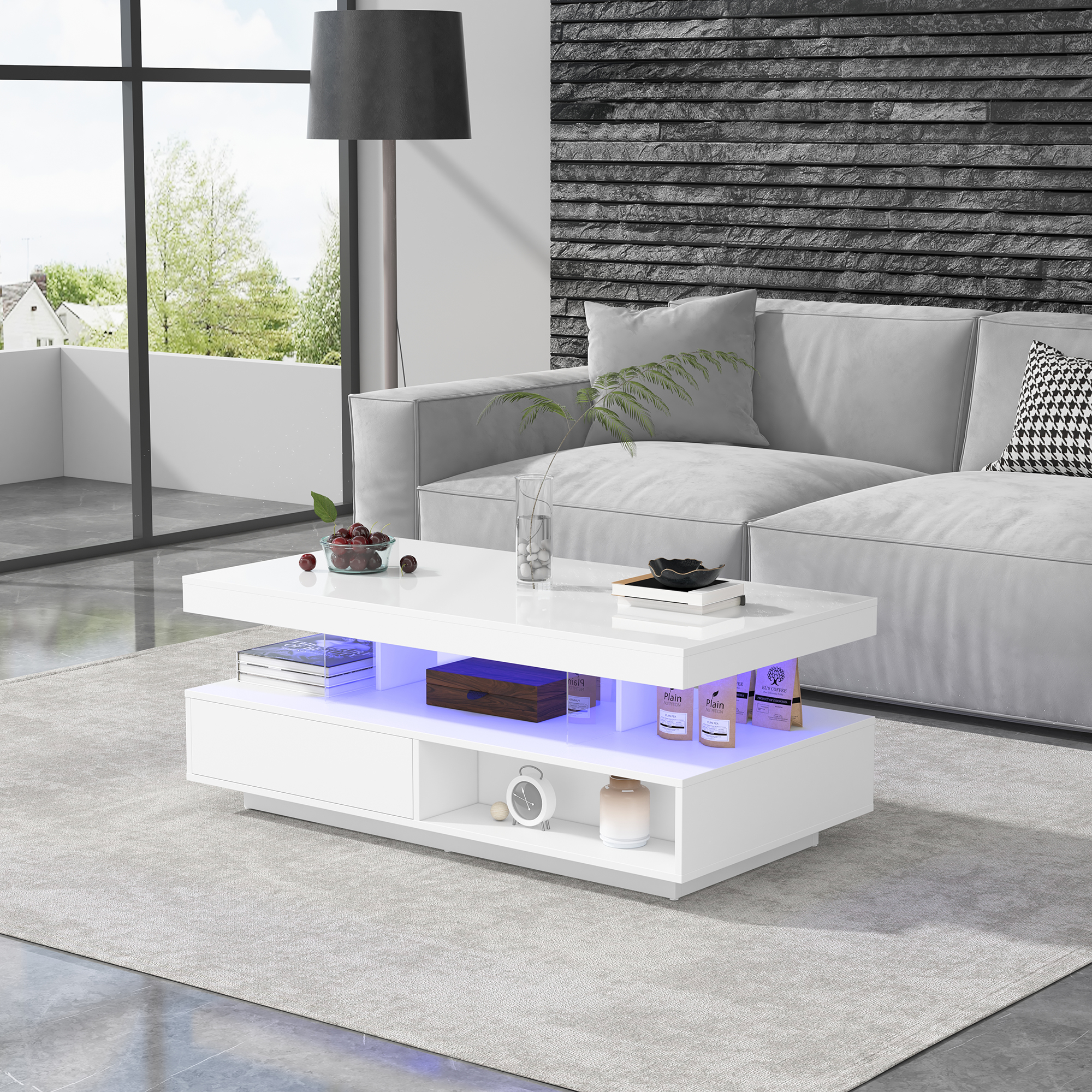 Ein weißer Couchtisch mit blau beleuchtetem Fach steht vor einem grauen Sofa.