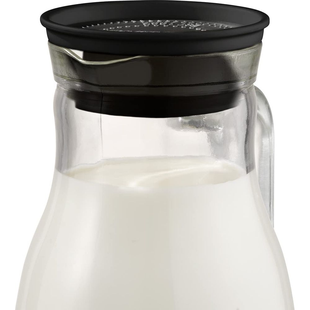 Milchkrug mit schwarzem Deckel, gefüllt mit weißer Milch.