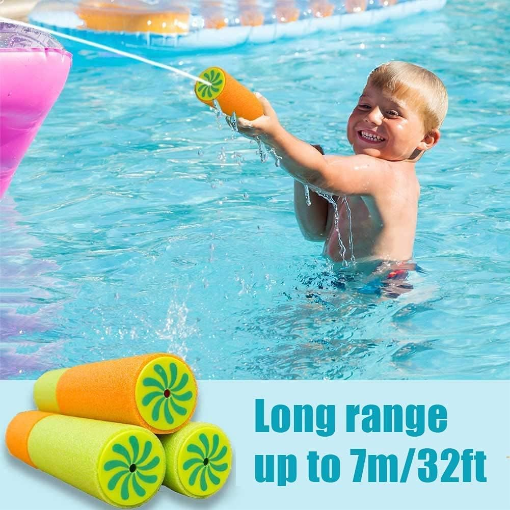 Ein Junge spritzt mit einer Wasserpistole im Pool, drei Schaumstoff-Wasserpistolen liegen vorne.