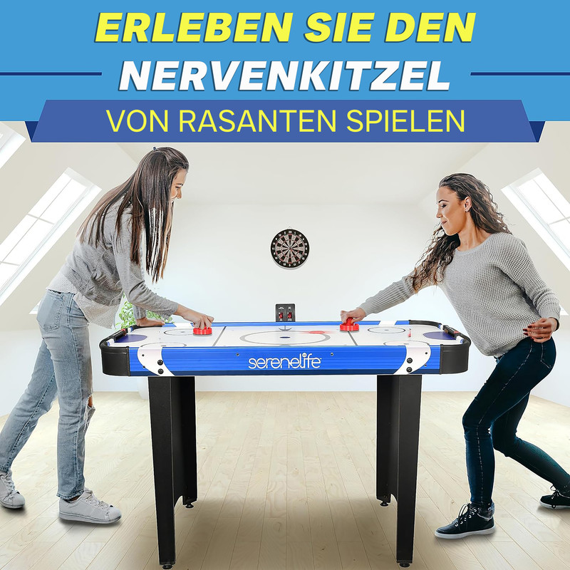 Zwei Frauen spielen Airhockey in einem hellen Raum mit Dachfenstern.
