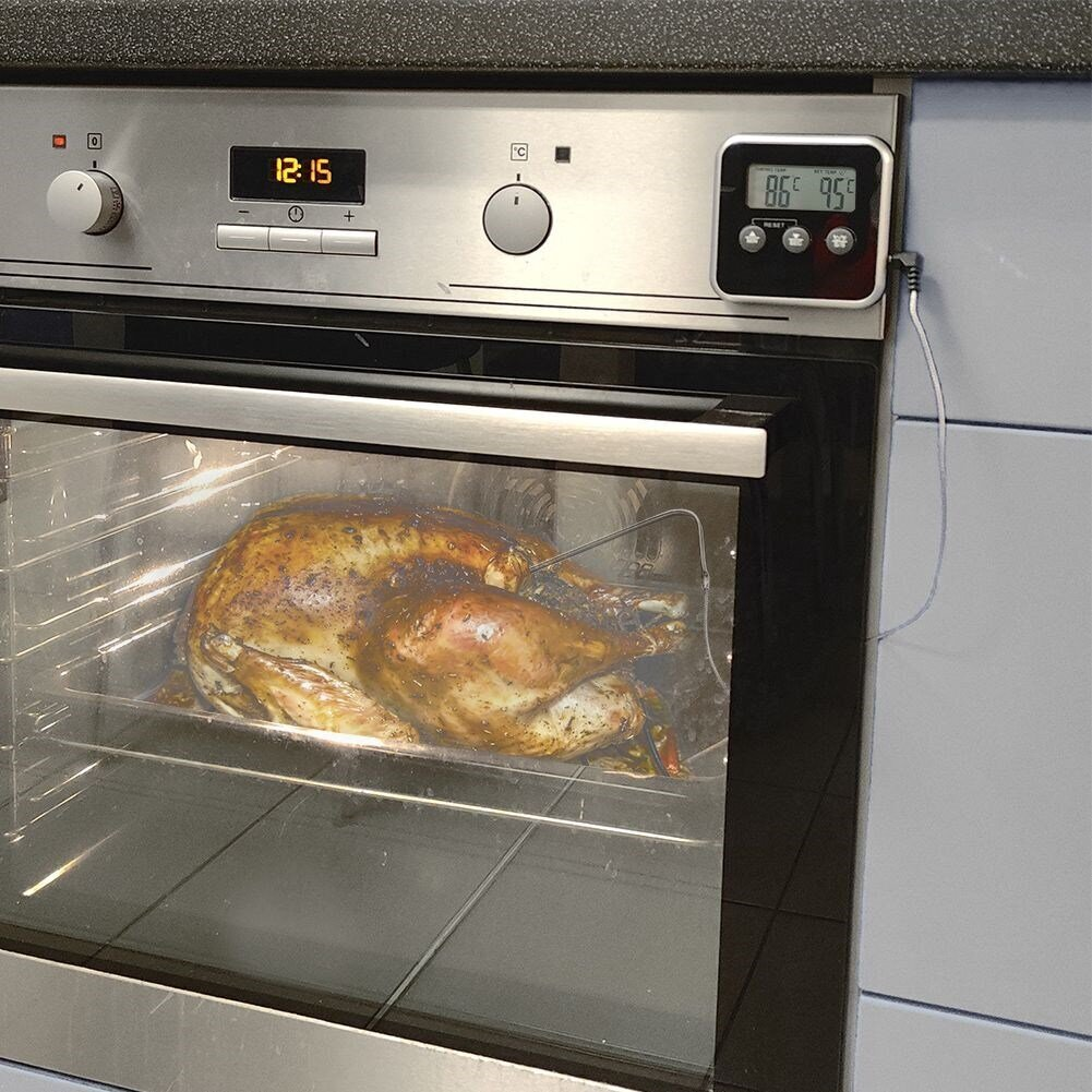 Ein gebratenes Truthuhn mit Gewürzen im Ofen, auf einem Rost liegend, mit einem Thermometer.