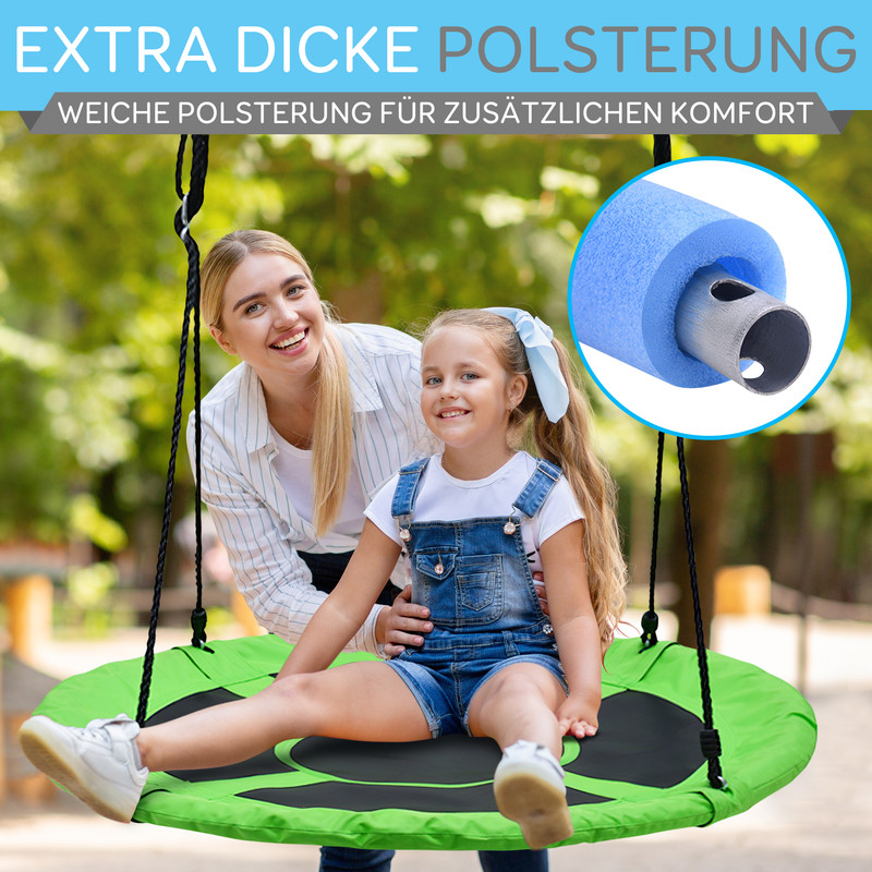 Frau und Kind auf einer grünen Nestschaukel im Freien, mit Nahaufnahme einer blauen Polsterung.