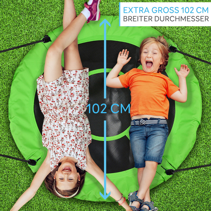 Zwei Kinder liegen auf einer runden, grünen Schaukel auf Gras. Der Durchmesser ist 102 cm.