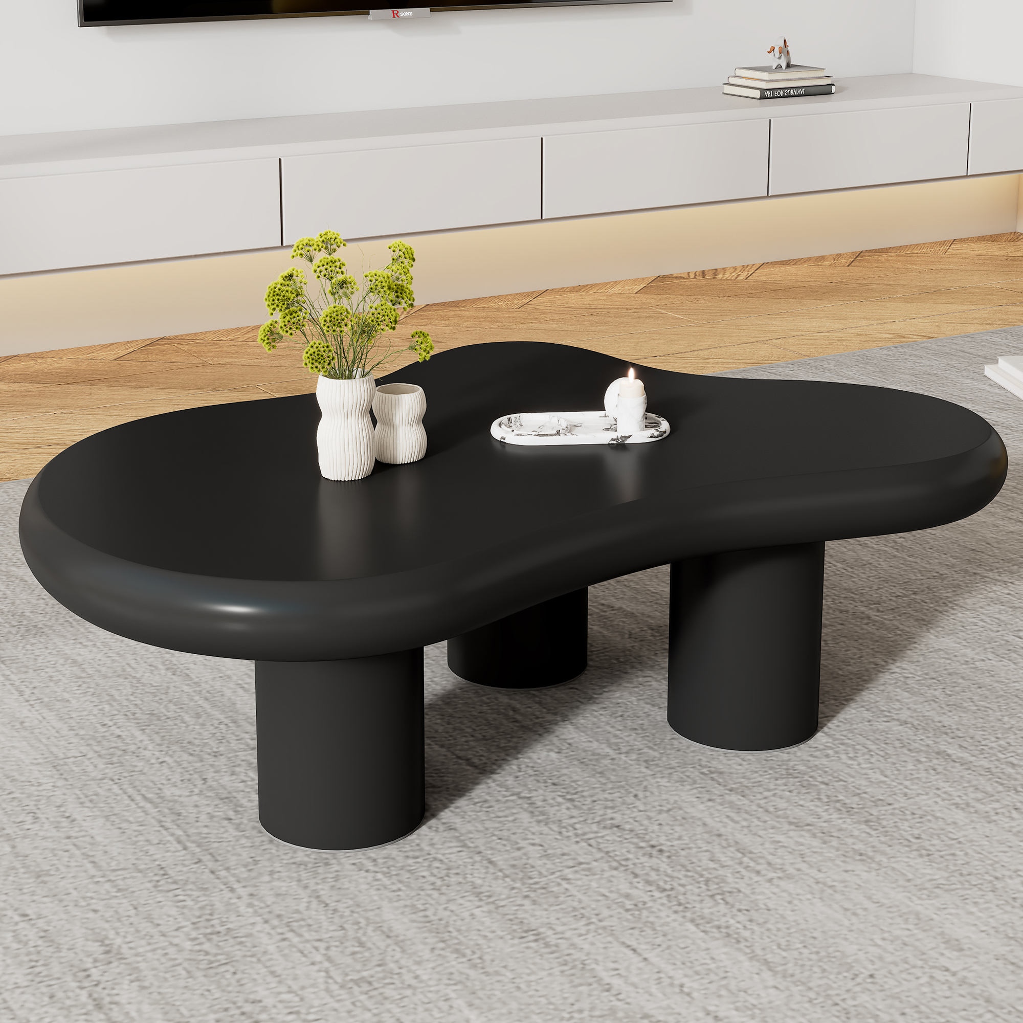 Schwarzer Couchtisch mit Vasen, Kerze und Büchern auf einem Teppich.