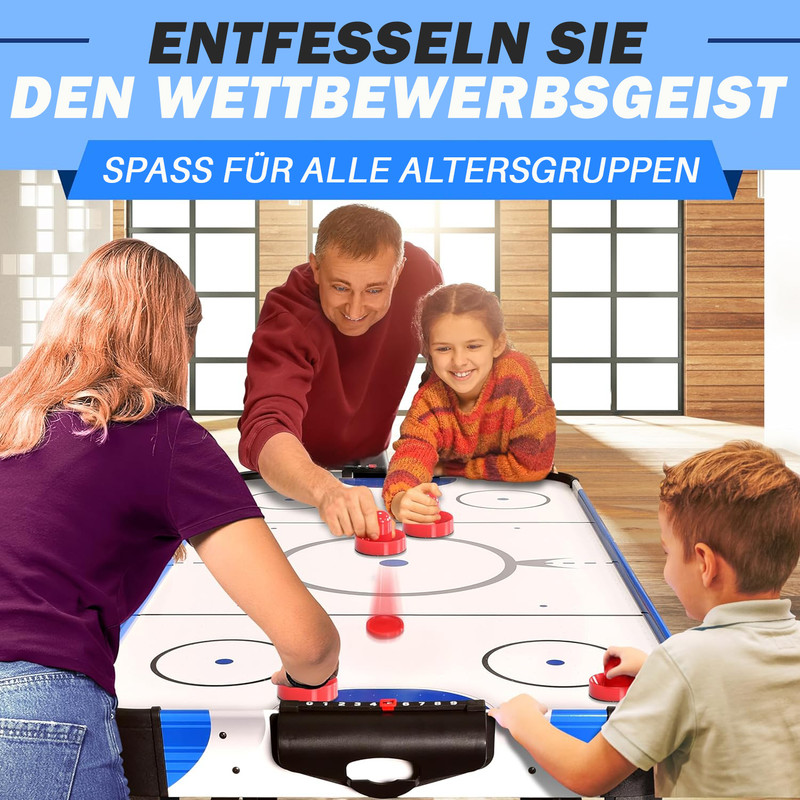 Familie spielt Airhockey. Vater und Kinder spielen mit roten Schlägern.