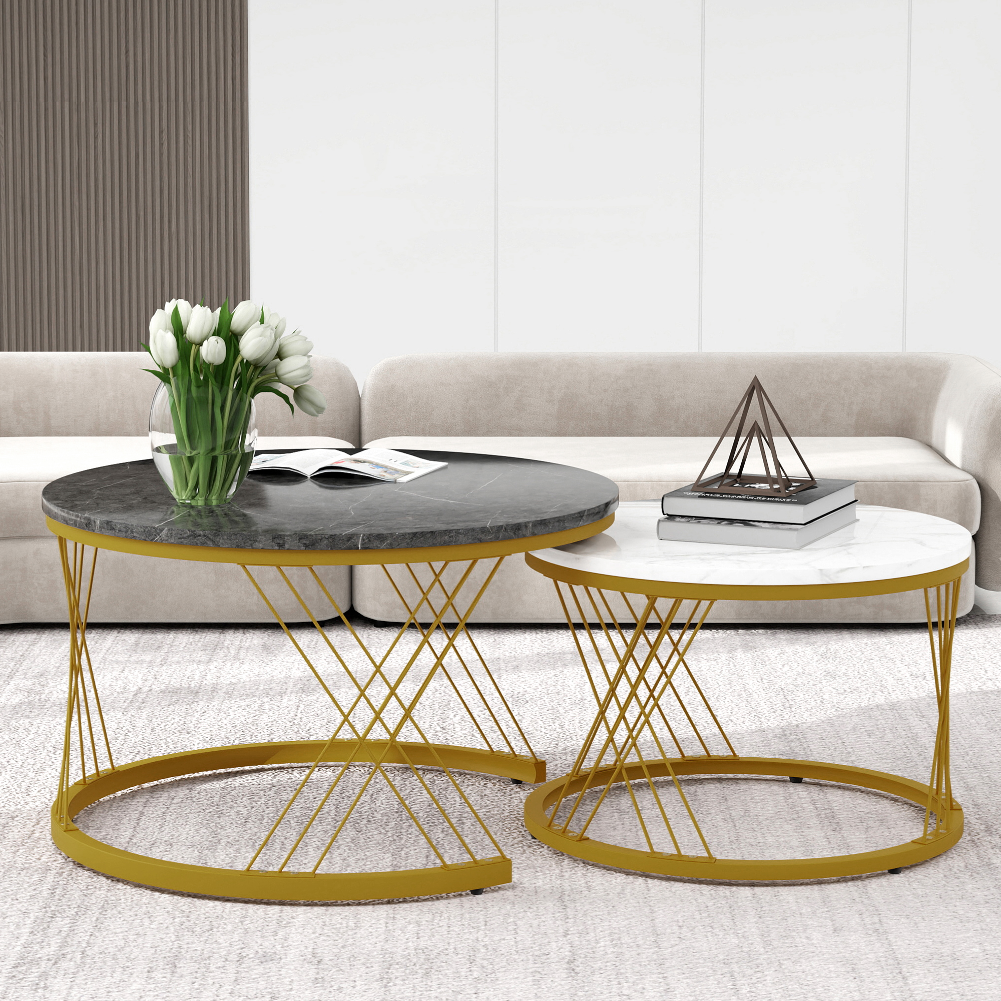 Zwei Marmortische mit goldenen Beinen vor einem Sofa. Weiße Tulpen auf dem größeren Tisch.