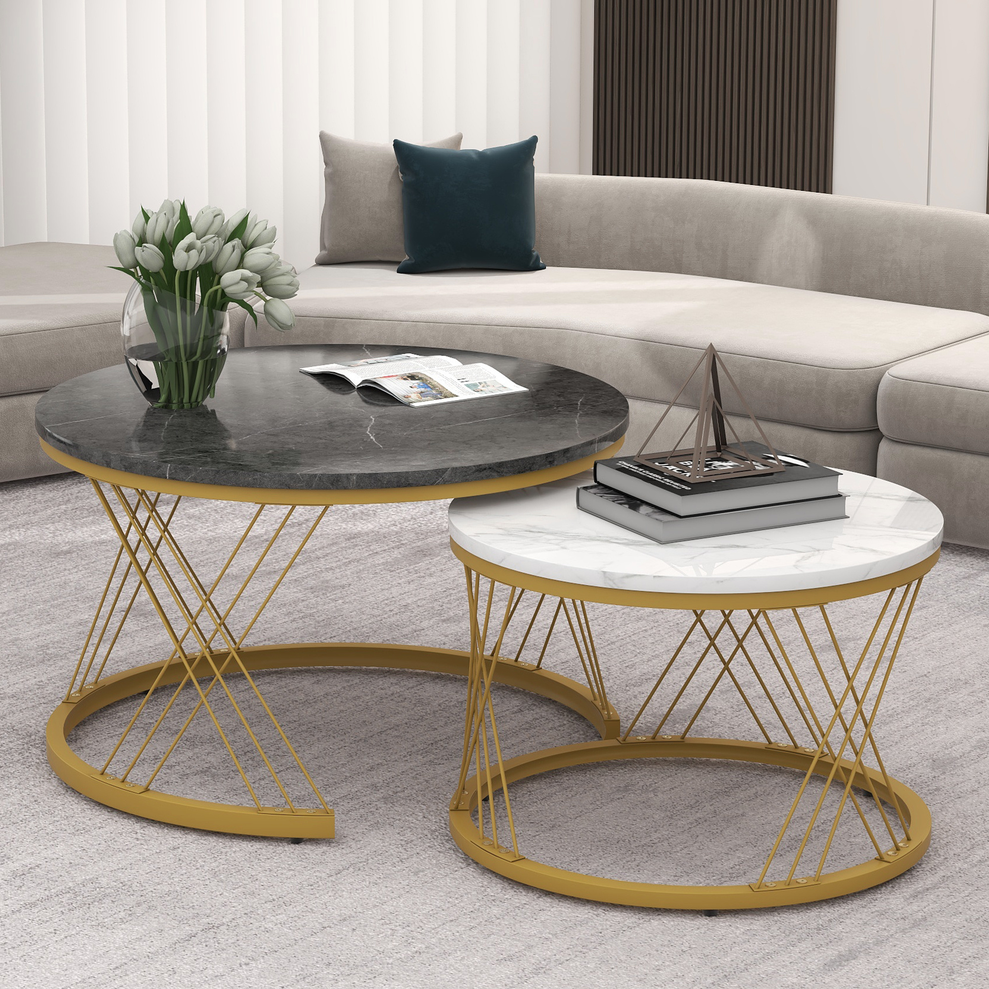 Zwei runde Couchtische mit Marmorplatte und goldenen Drahtgestellen vor einem Sofa.