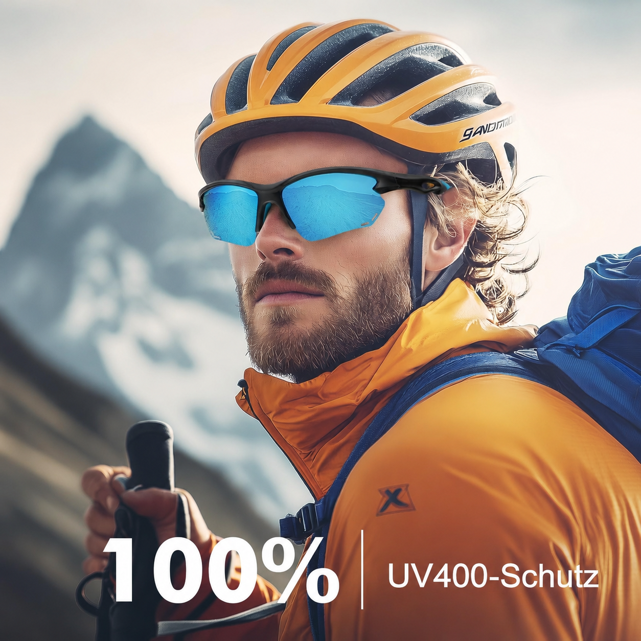 Mann mit orangefarbener Jacke, Helm, Sonnenbrille und Wanderstock vor Berg.