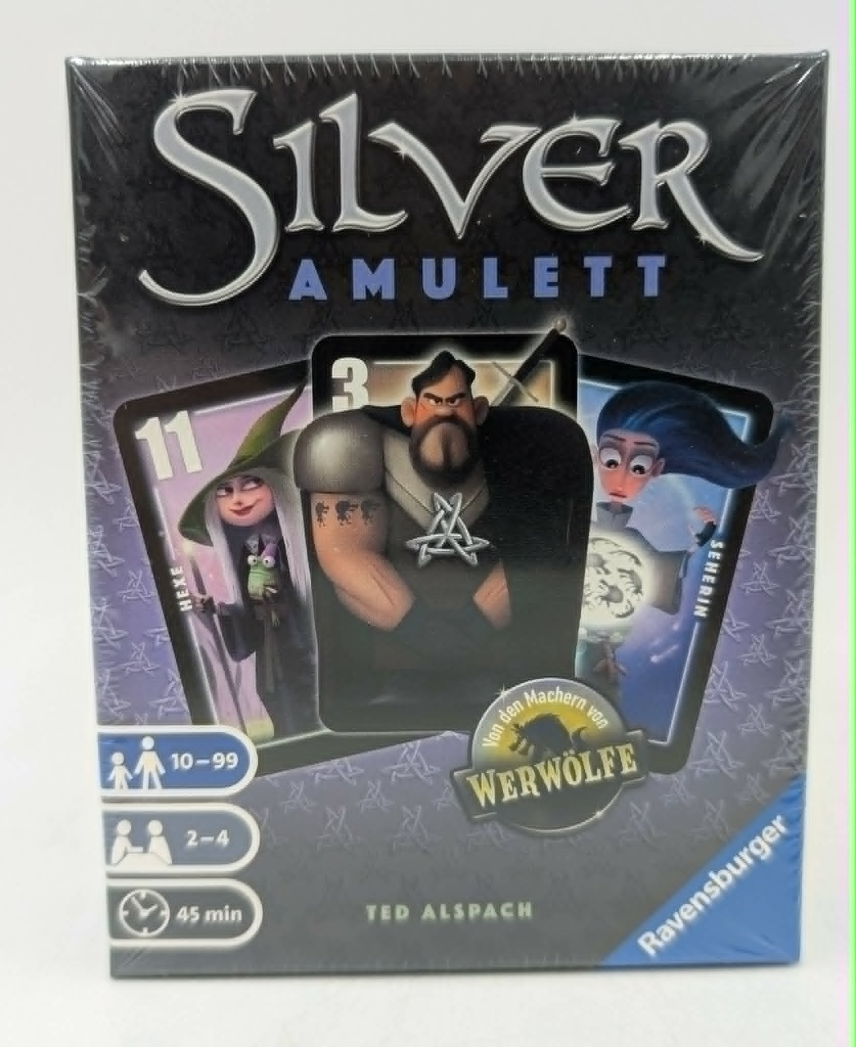 Verpackung des Brettspiels Silver Amulett mit Figuren einer Hexe, eines Mannes und eines Mädchens.