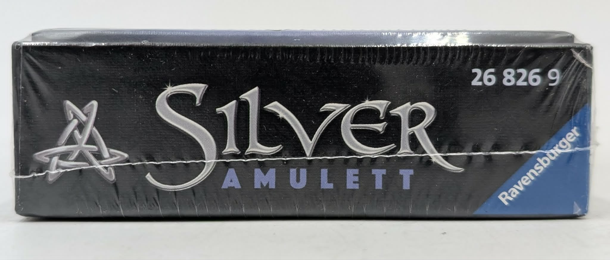 Schwarze Spielschachtel mit silbernem Schriftzug "Silver Amulett" und Ravensburger-Logo.