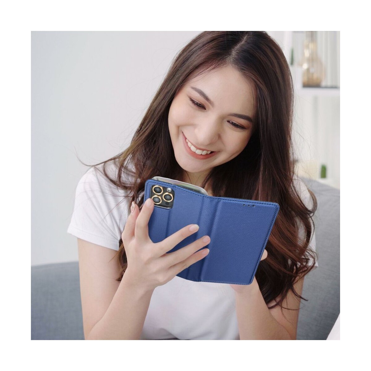Eine Frau hält ein blaues Handycover mit einem Handy darin.