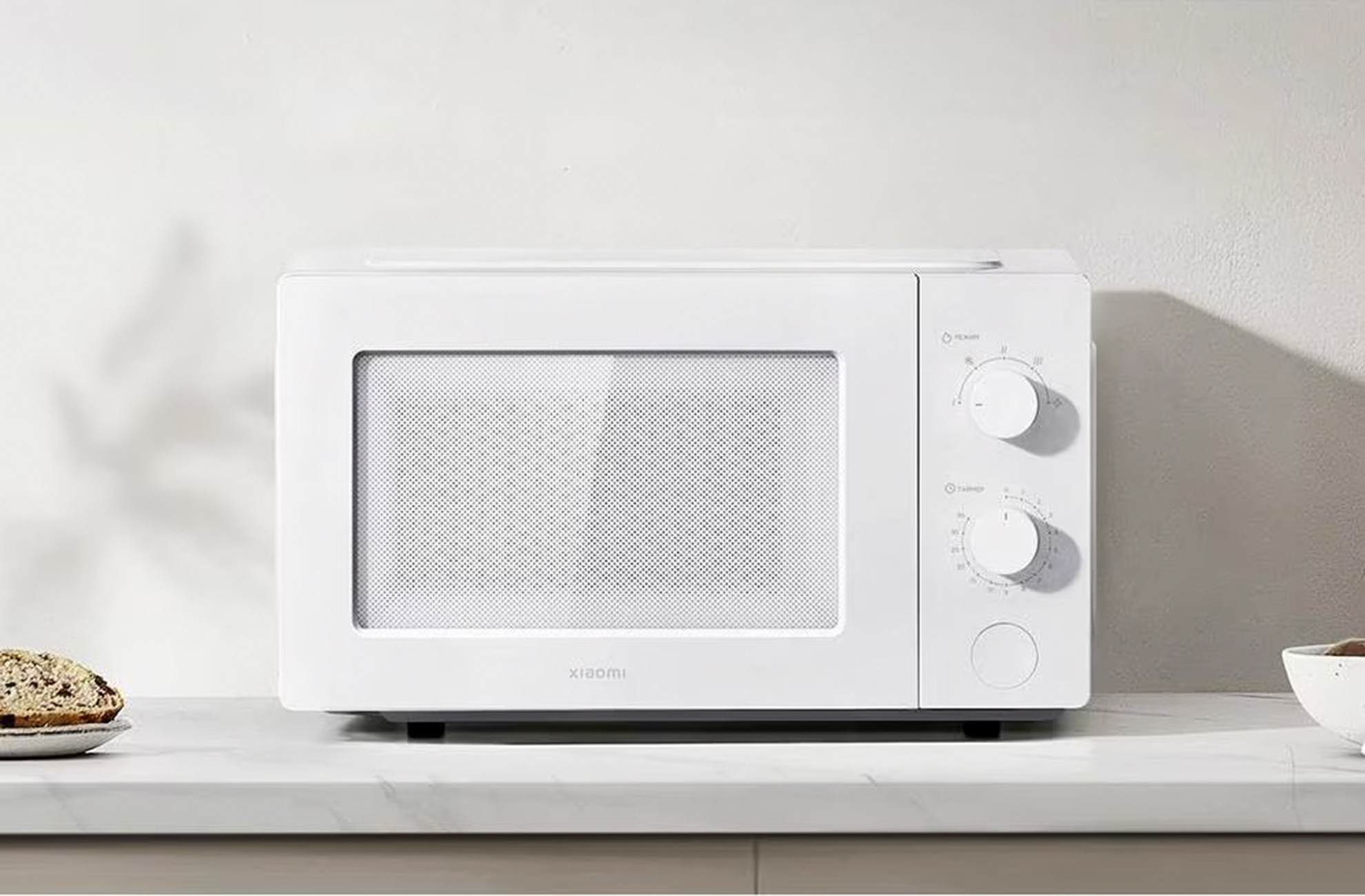 Un microonde bianco Xiaomi con due manopole e un pulsante rotondo.