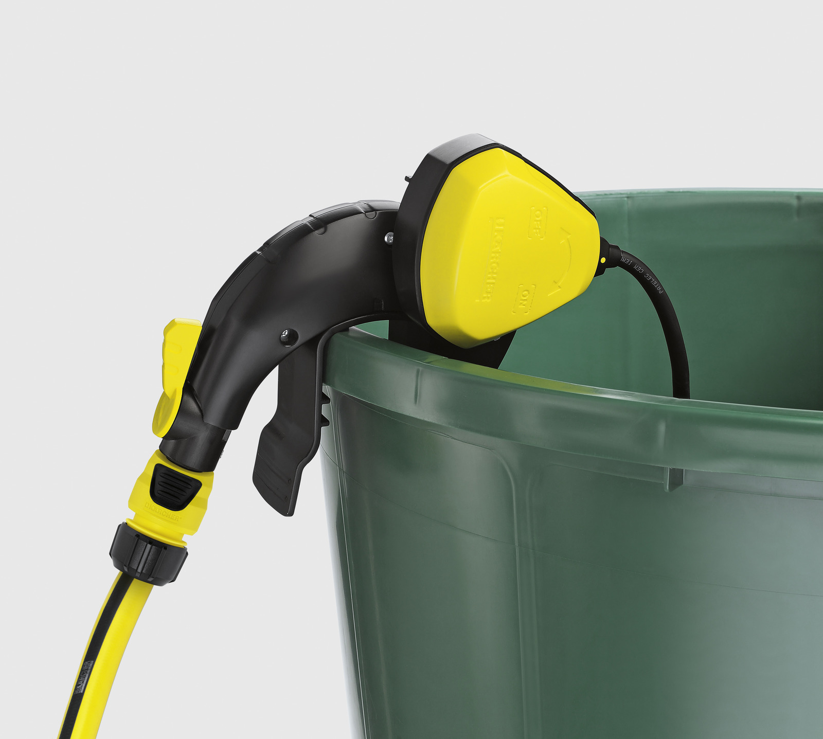 Una manguera amarilla y negra con un conector sujeto a un contenedor verde.