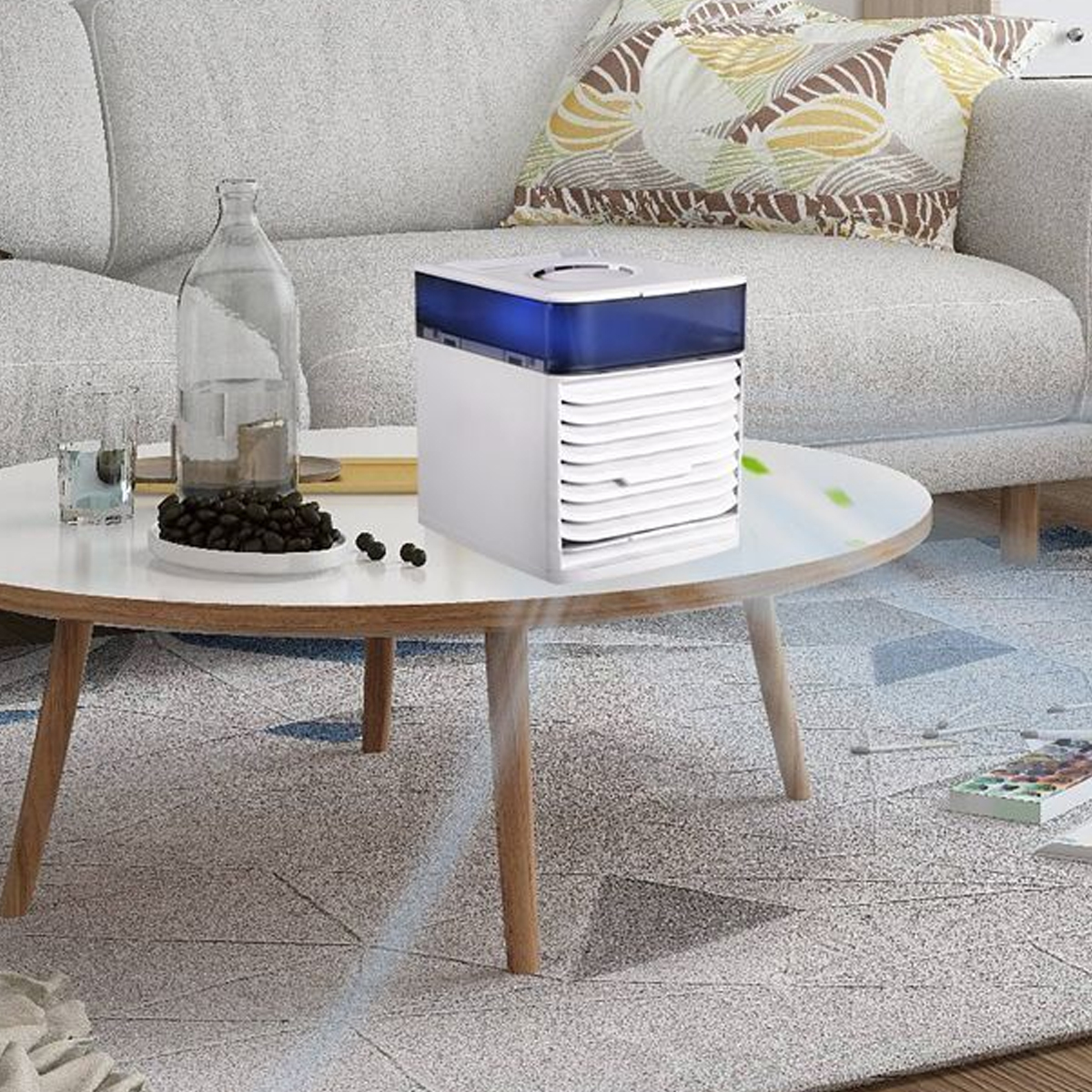 Ein weißer Luftkühler mit blauem Oberteil steht auf einem Couchtisch neben einer Glasflasche.