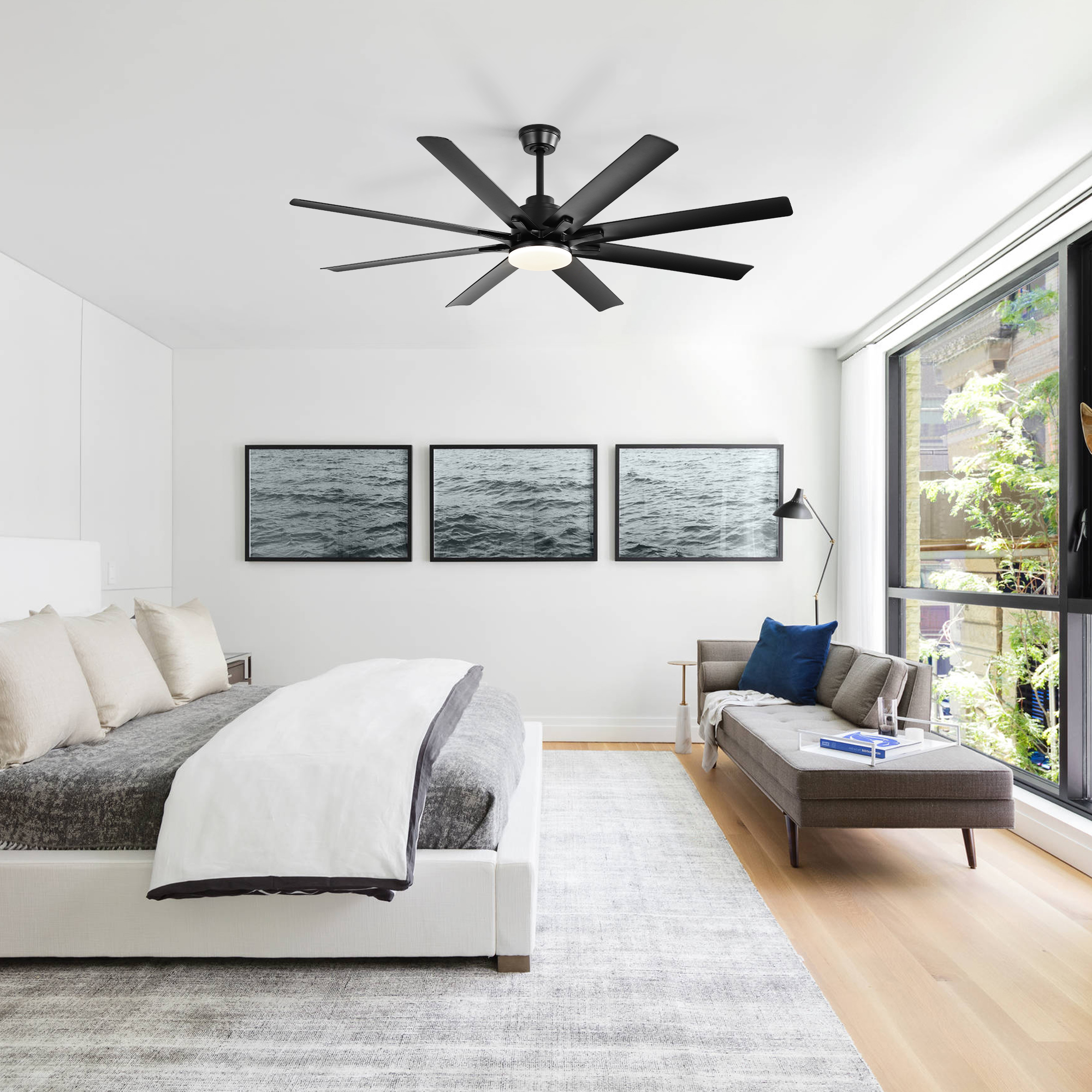 Modernes Schlafzimmer mit schwarzem Deckenventilator, Bett, Sofa und Fenstern.
