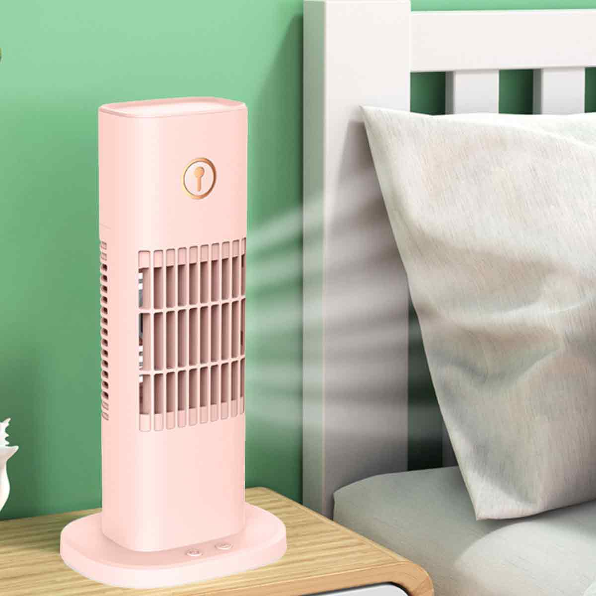 Ein rosafarbener Turmventilator steht auf einem Nachttisch neben einem Bett mit weißen Kissen.