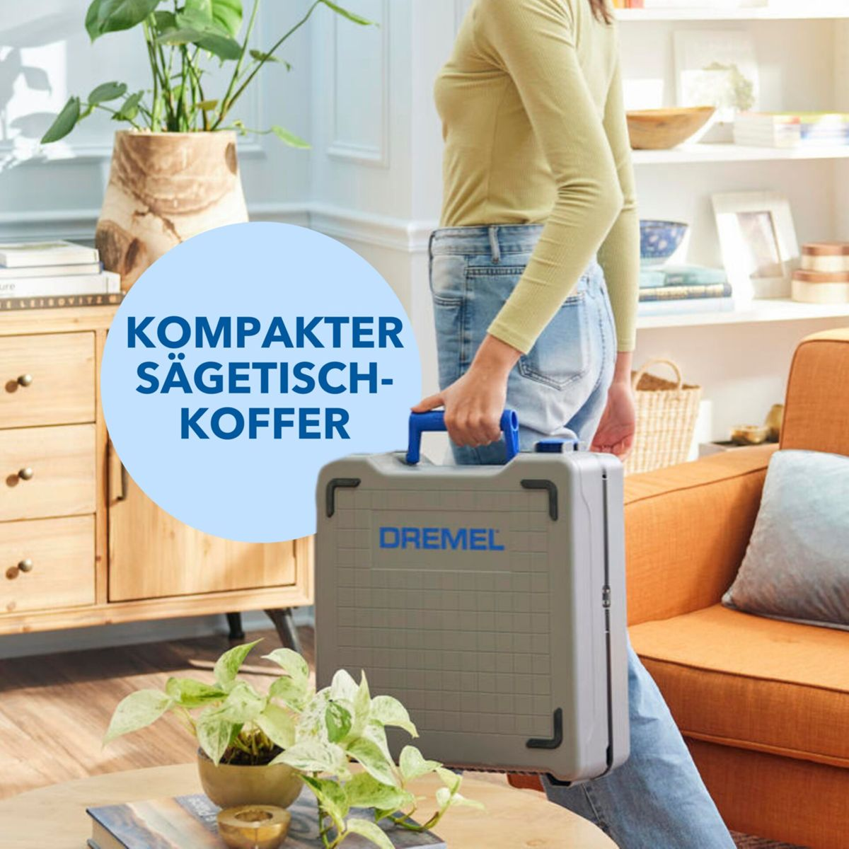 Eine Person trägt eine graue Dremel-Werkzeugkiste mit blauem Griff.