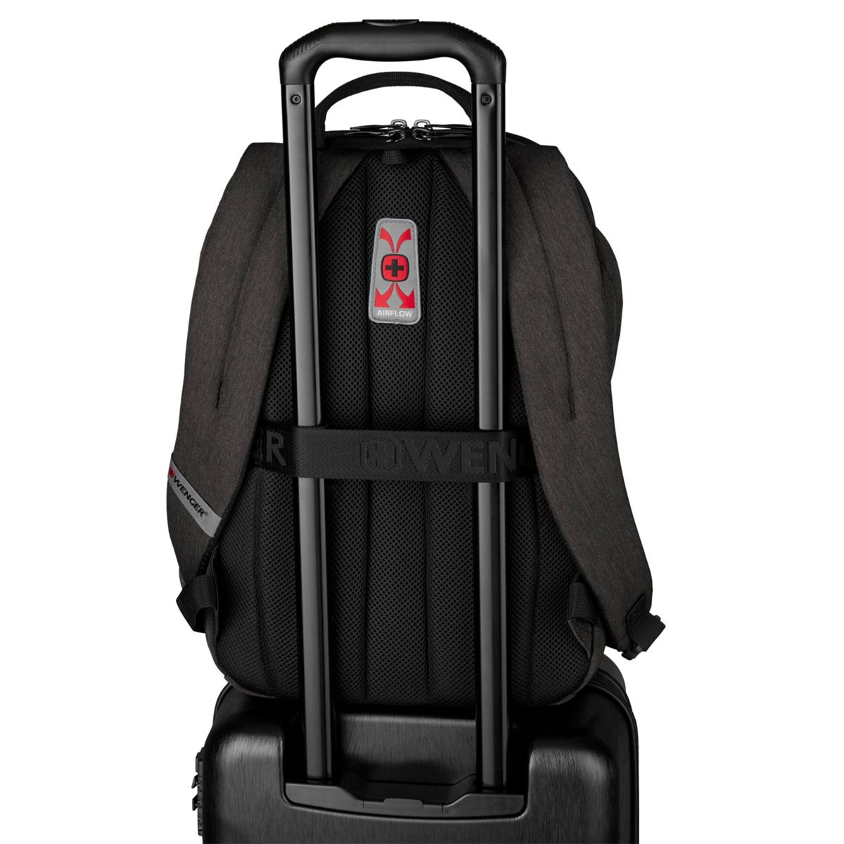 Rückansicht eines schwarzen Rucksacks mit silbernem Griff auf einem Koffer.