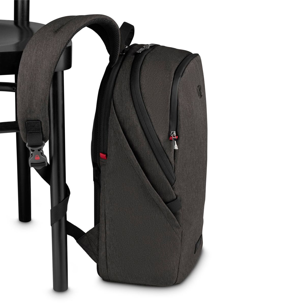 Dunkelgrauer Rucksack mit schwarzem Reißverschluss, an einem schwarzen Stuhl befestigt.