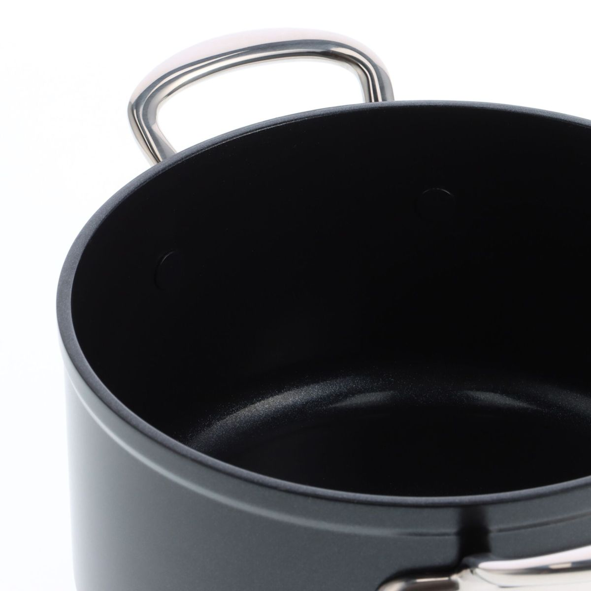 Nahaufnahme eines schwarzen Kochtopfes mit silbernem Griff.