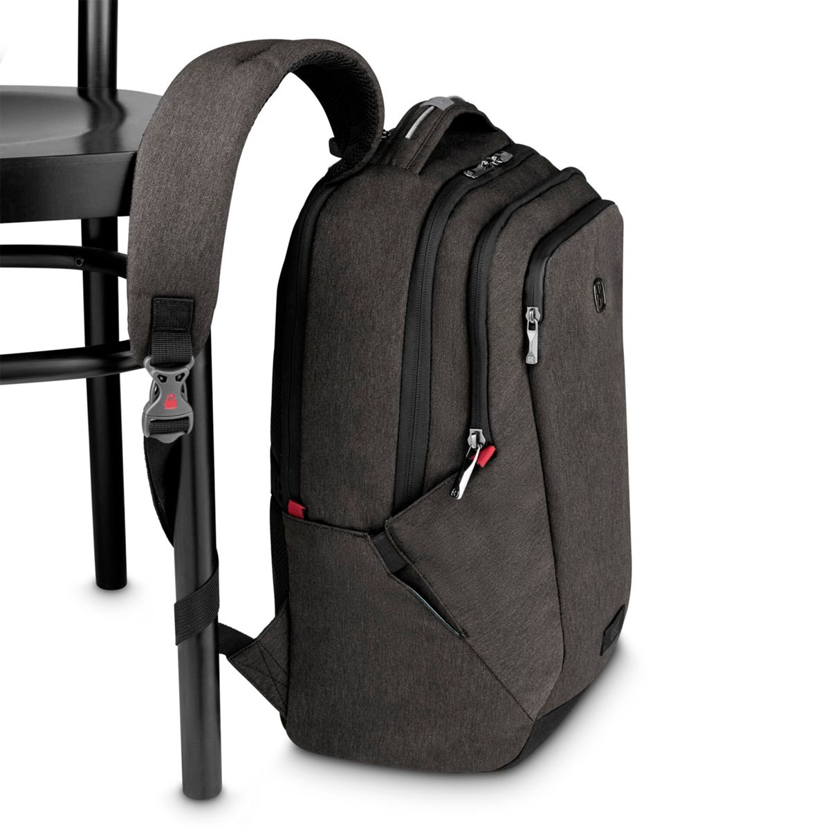 Dunkelgrauer Rucksack mit Reißverschlüssen, angelehnt an einen Stuhl.