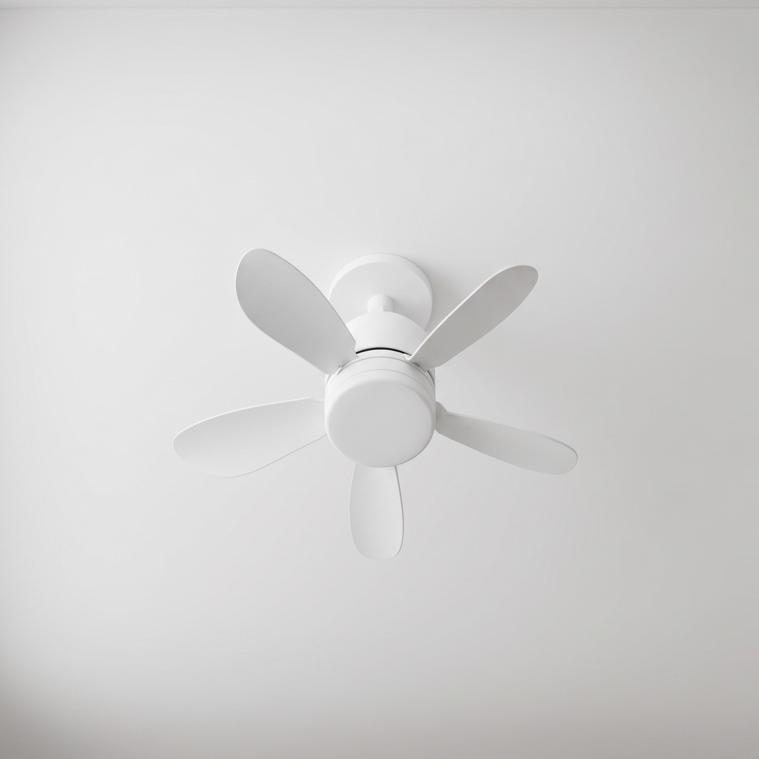 Un ventilador de techo blanco con cinco aspas está montado en un techo blanco.