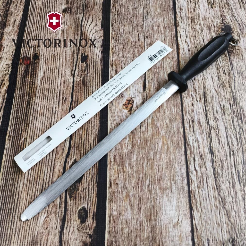 Ahşap zemin üzerinde siyah saplı Victorinox bileme çeliği.