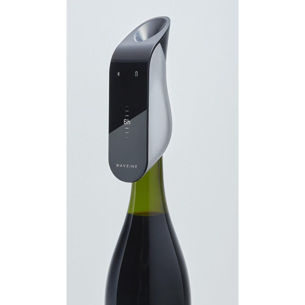 Un tappo per vino argentato e nero con display digitale su una bottiglia di vino.