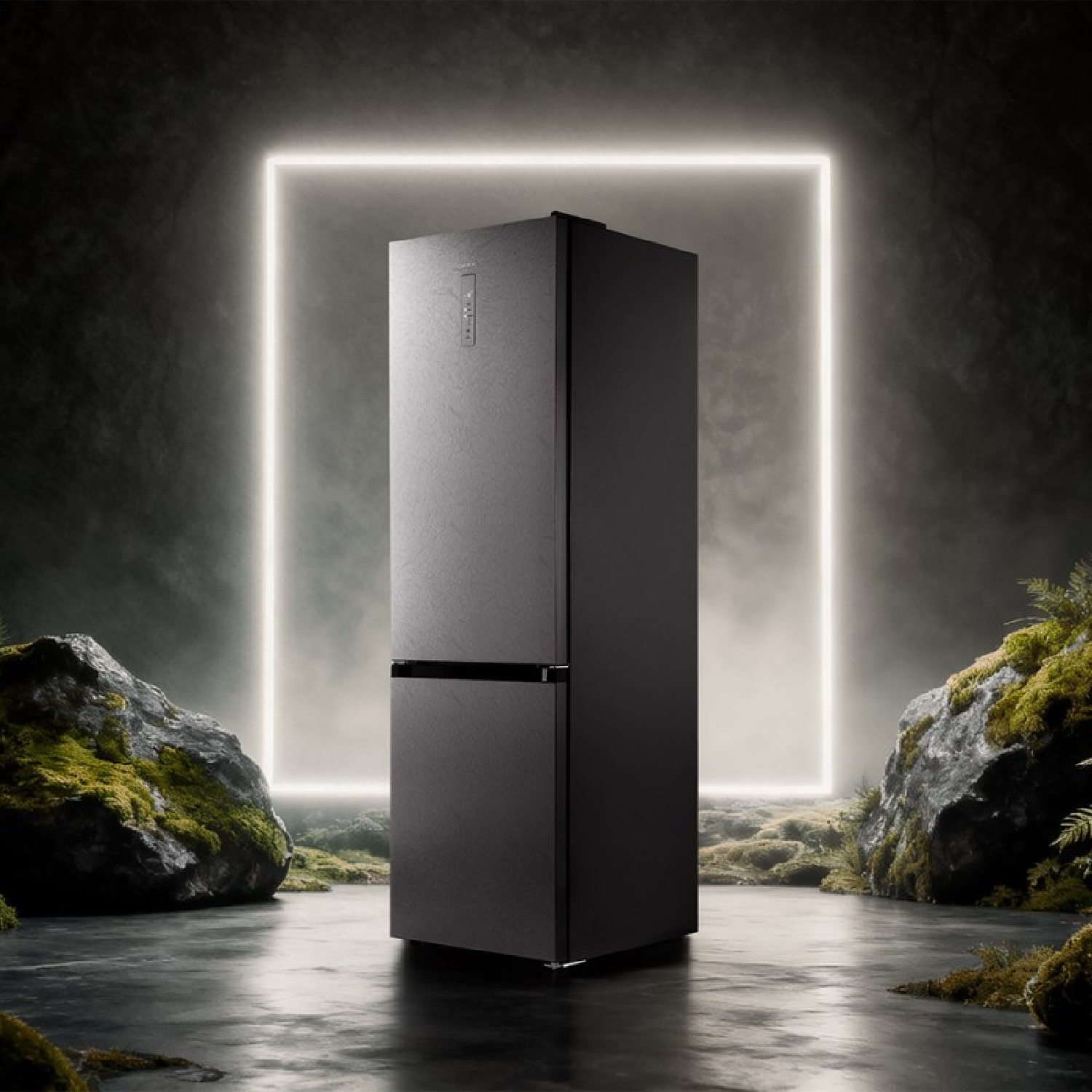 Un refrigerador negro frente a un cuadrado brillante, rodeado de rocas y vegetación.