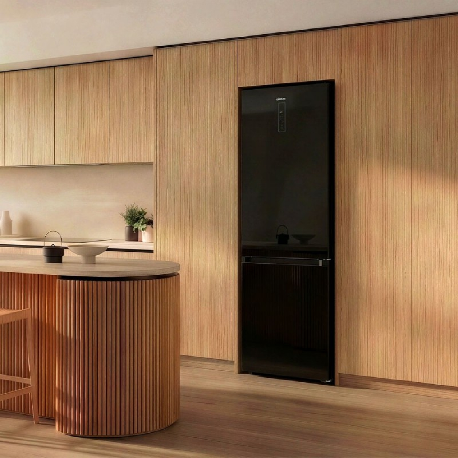 Un refrigerador negro en una cocina moderna con gabinetes de madera y una isla redonda.