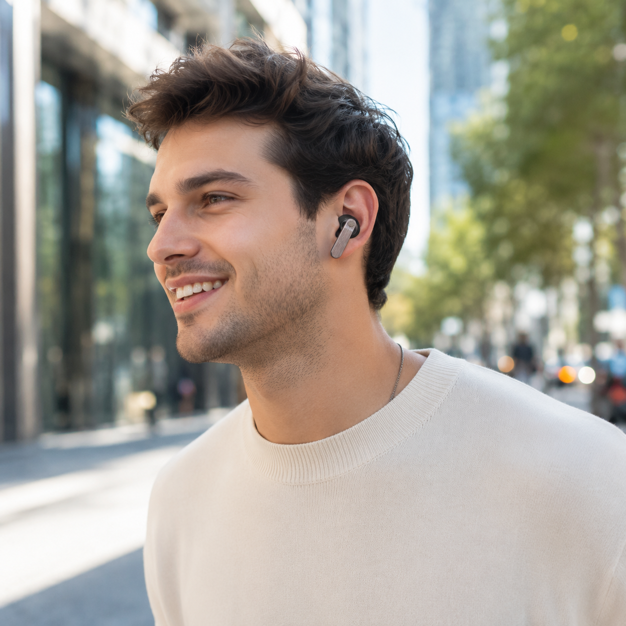 Un hombre con auriculares sonríe, con edificios y árboles borrosos al fondo.