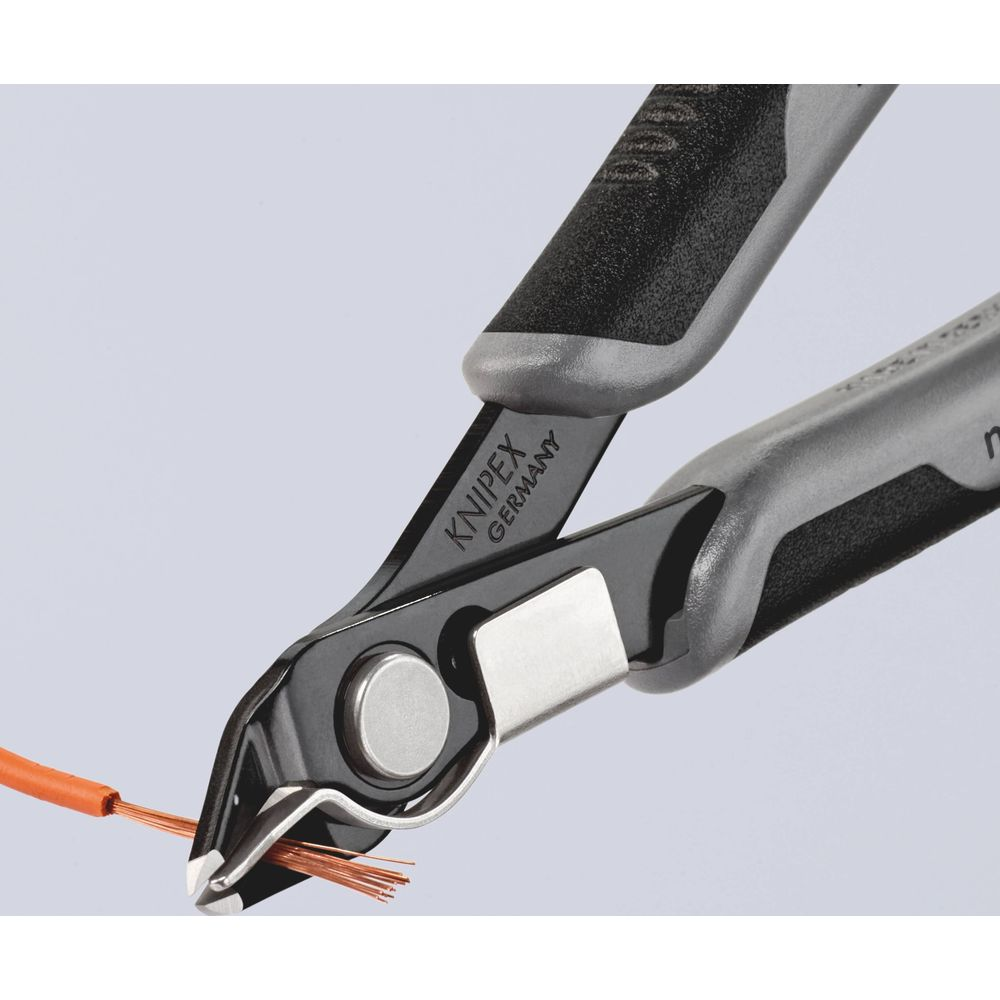 Pinze Knipex tagliano un filo arancione con fili di rame.