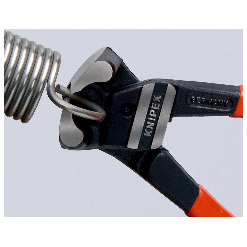 Primo piano di pinze Knipex nere e arancioni che tagliano una molla metallica, su uno sfondo grigio chiaro semplice.