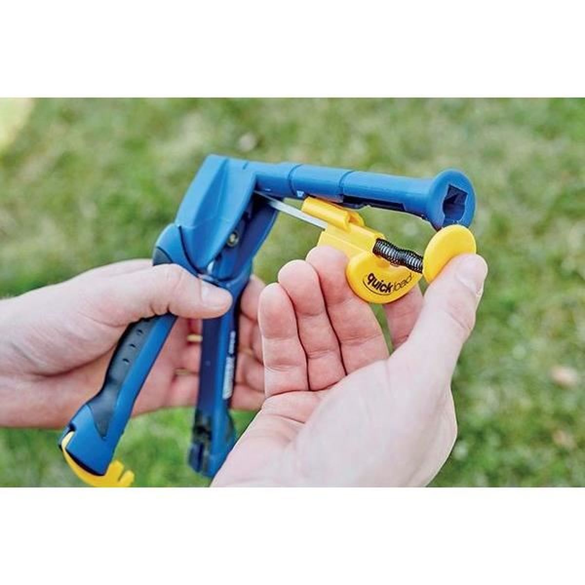 Pinza blu con attacco giallo etichettato 'Quickload', tenuta dalle mani.