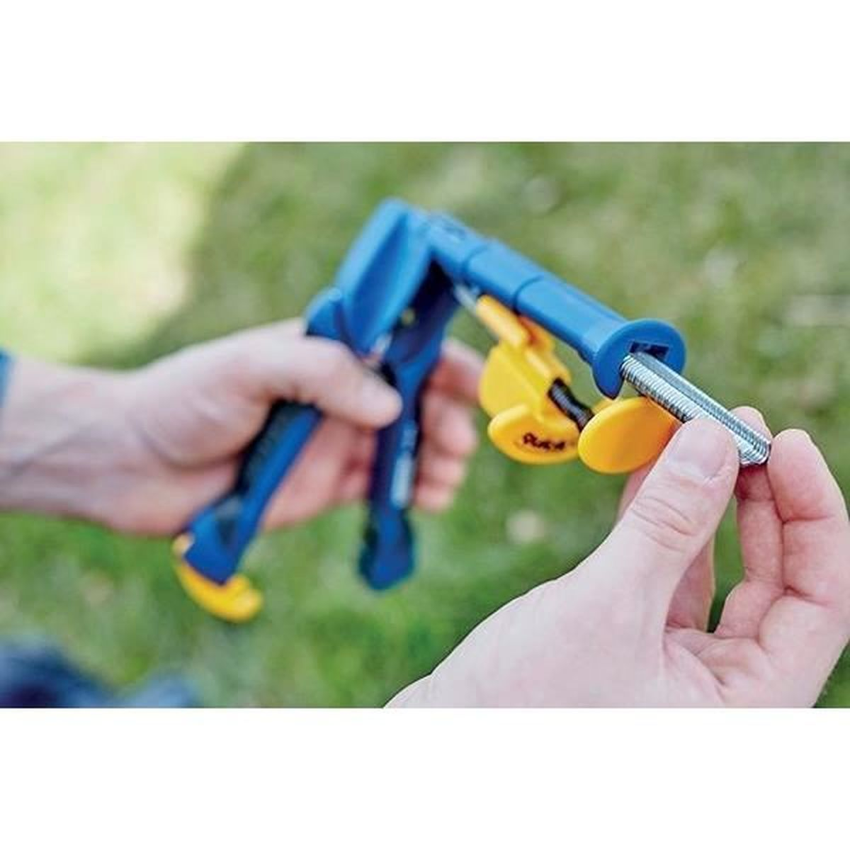 Una pinza blu con accenti gialli tiene un bullone filettato.