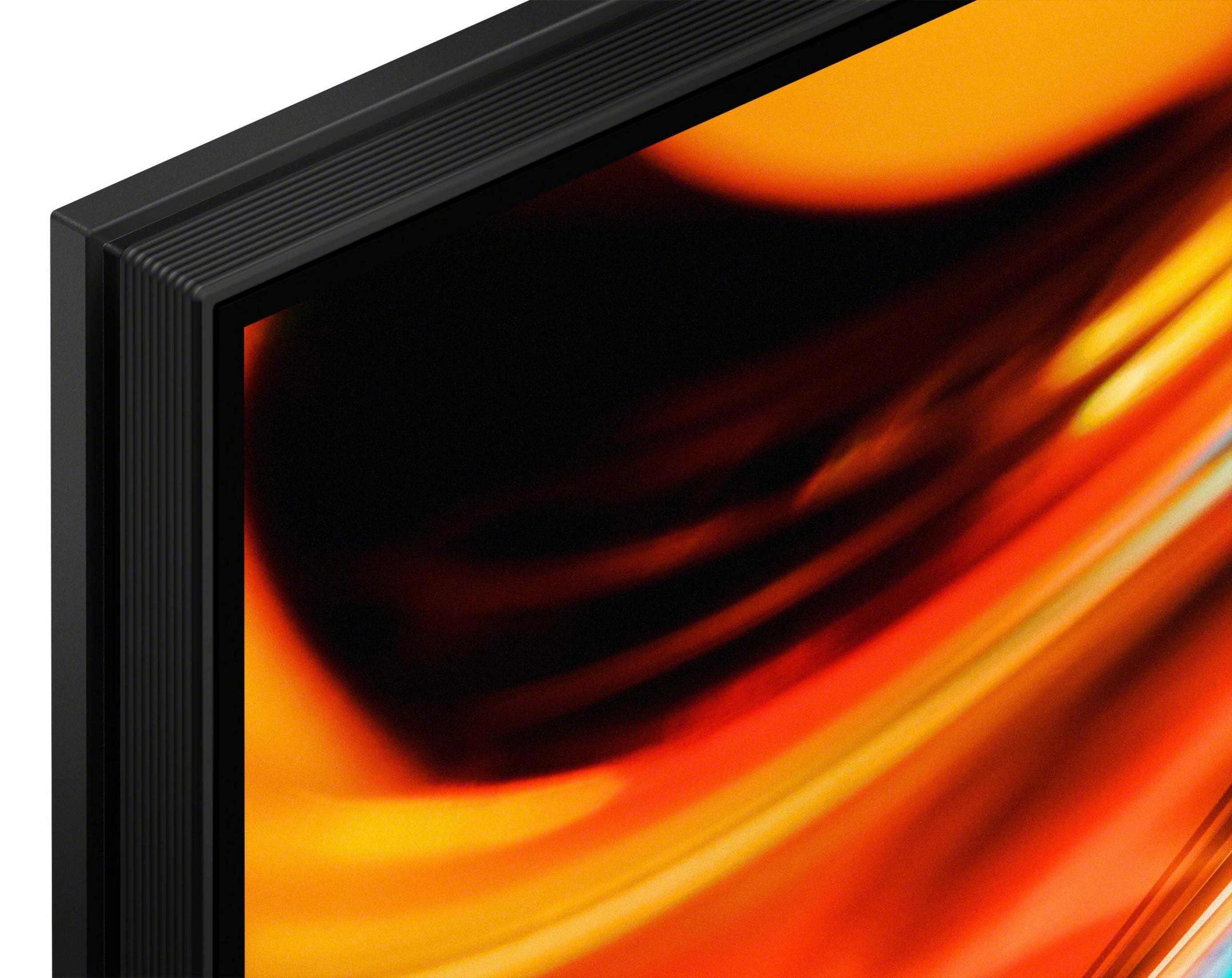 Primer plano del marco negro de un televisor con un patrón abstracto naranja en la pantalla.